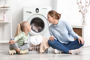 Mutter und Tochter vor Waschmaschine
