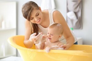 mutter badet ihr kleines baby in einer wanne