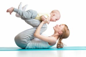 Mutter macht mit Ihrem Baby Gymnastik