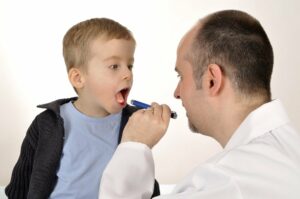 Arzt schaut Kind in den Hals