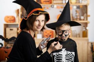 Mutter schminkt ihren Sohn für Halloween als Skelett
