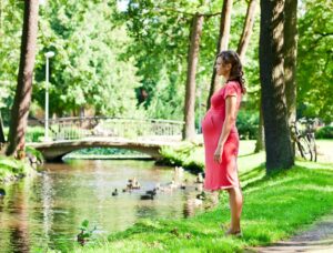 junge, schwangere Frau in einem Park